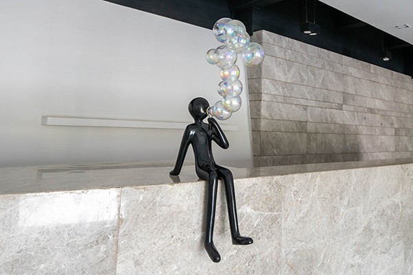 Elevate your interior or commercial space with this Fiberglass Sitting Figure Sculpture with Bubble Design